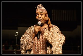 Porträt des Gospelsängers Folarin Omishade mit Mikrofon in der Hand
