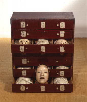 Cabinet with open drawers containing masks