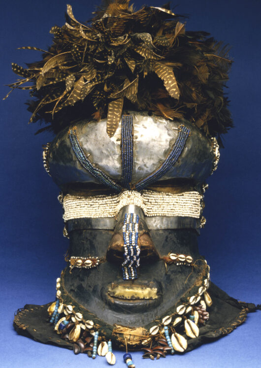 Maske mit Perlen und Muscheln bestickt und Federn obendrauf