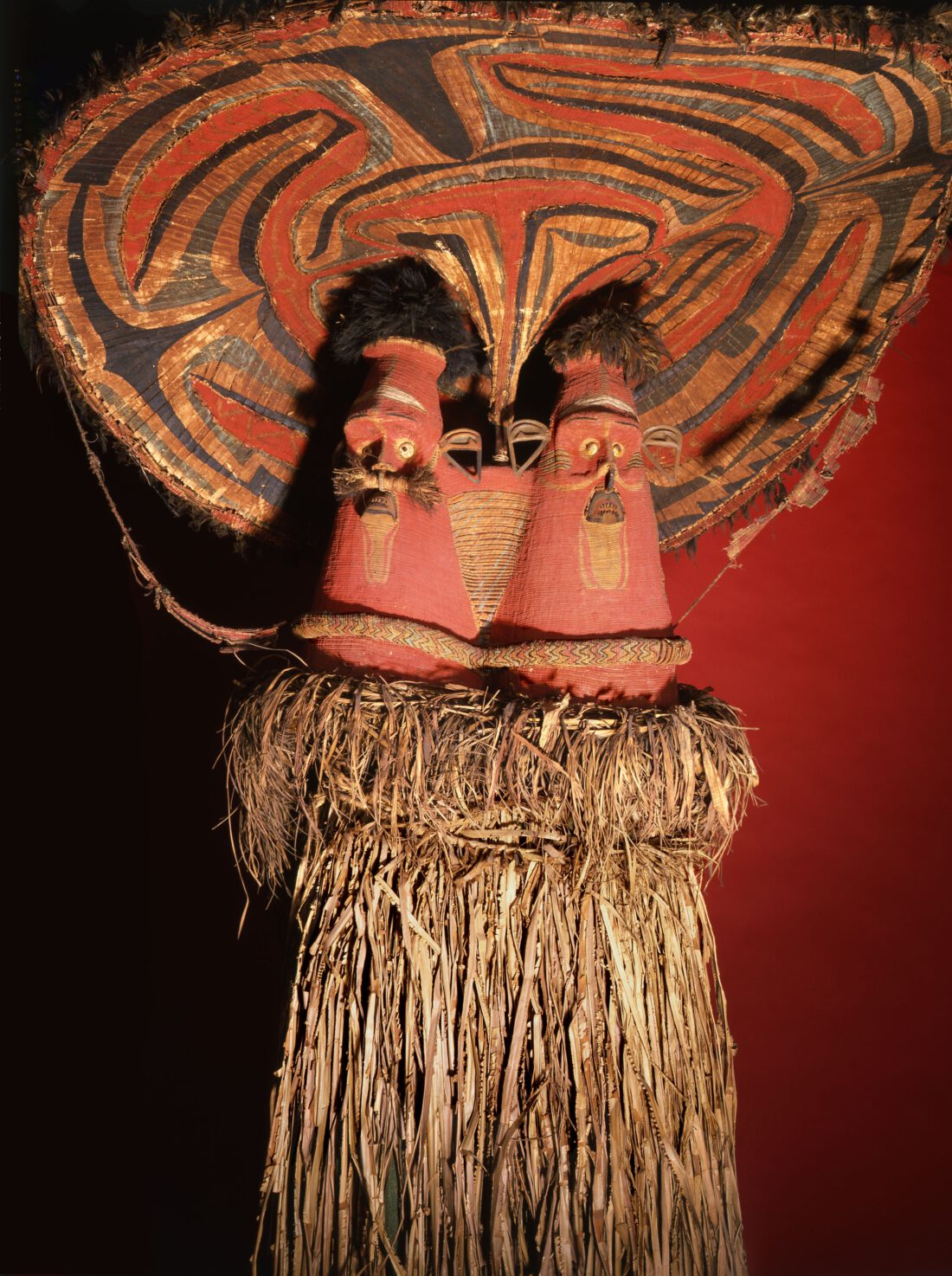 colourful mask with two faces made of bamboo, plant fibres and feathers