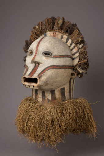 Maske, verziert mit Bast und Federn, die einen Kopf darstellt