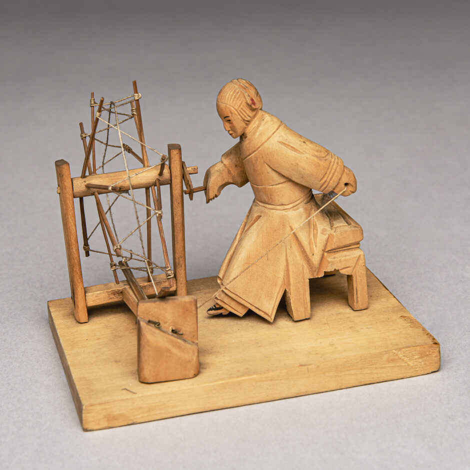 Woman with bound feet at spinning wheel