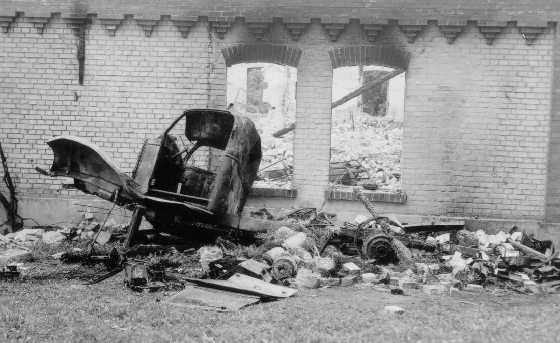 war damage, building, remnants of a vehicle, rubble, b/w photograph